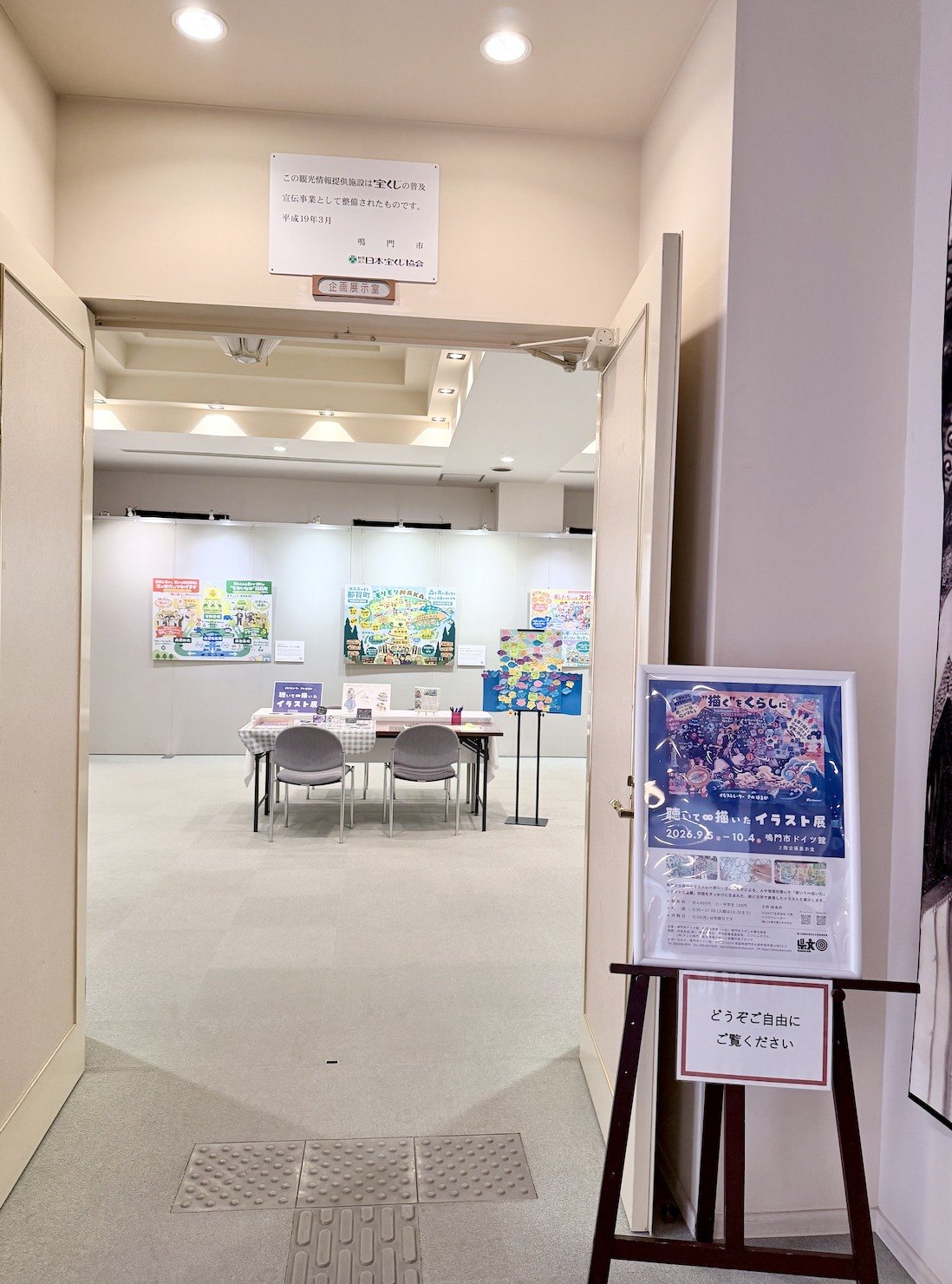 鳴門市ドイツ館2階 企画展示室の入口。『聴いて∞描いたイラスト展』のポスターと案内